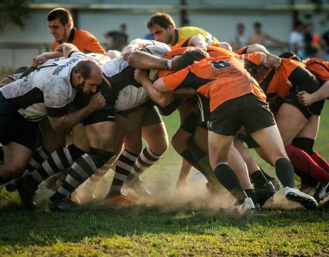 Rugbyteam in een scrum als metafoor voor samenwerking en gezamenlijke verantwoordelijkheid binnen een Scrum Team.